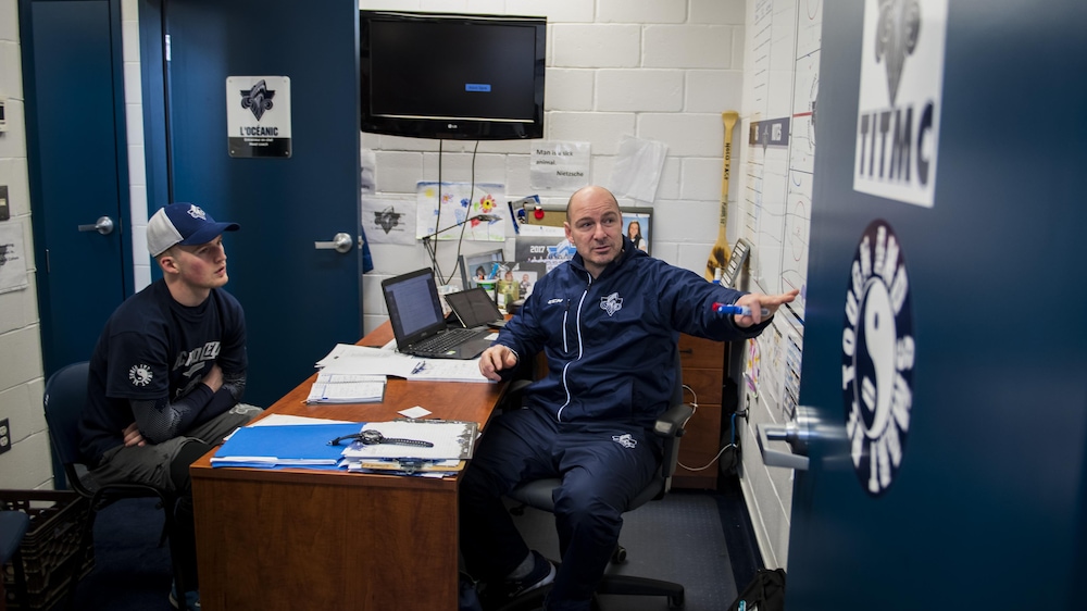Alexis Lafrenière écoute attentivement les directives de son entraîneur Serge Beausoleil, au Colisée de Rimouski.