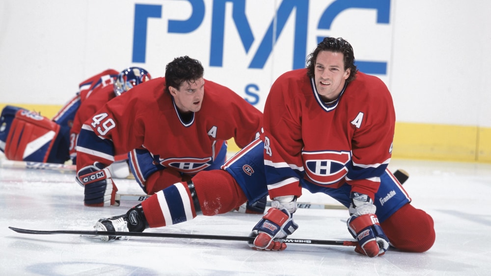 Patrice Brisebois (droite) et Brian Savage font des étirements avant un match du Canadien de Montréal, en 2002.