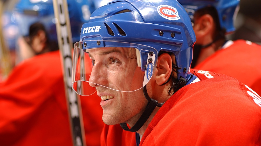 Patrice Brisebois, en 2003 sur le banc du Canadien, regarde l'action qui se passe sur la glace.