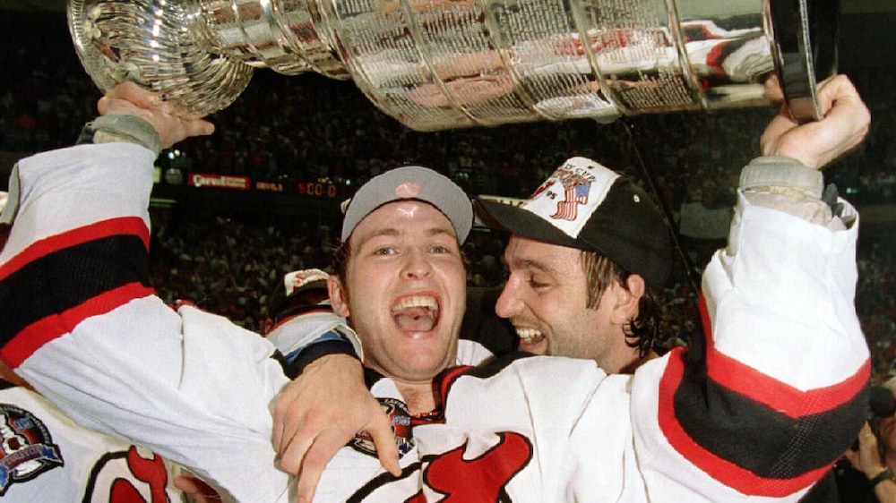 Stéphane Richer (droite) enlace Martin Brodeur après la conquête de la Coupe Stanley par les Devils du New Jersey contre les Red Wings de Détroit en juin 1995.
