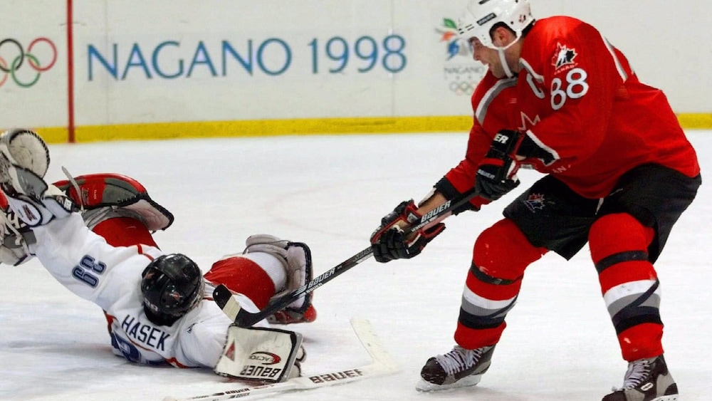 Dominik Hasek, de la République tchèque, empêche Eric Lindros, du Canada, de marquer pendant la séance de tirs de barrage.