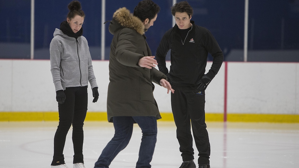 Tessa Virtue (gauche) et Scott Moir (droite) à l'entraînement avec Patrice Lauzon (centre)