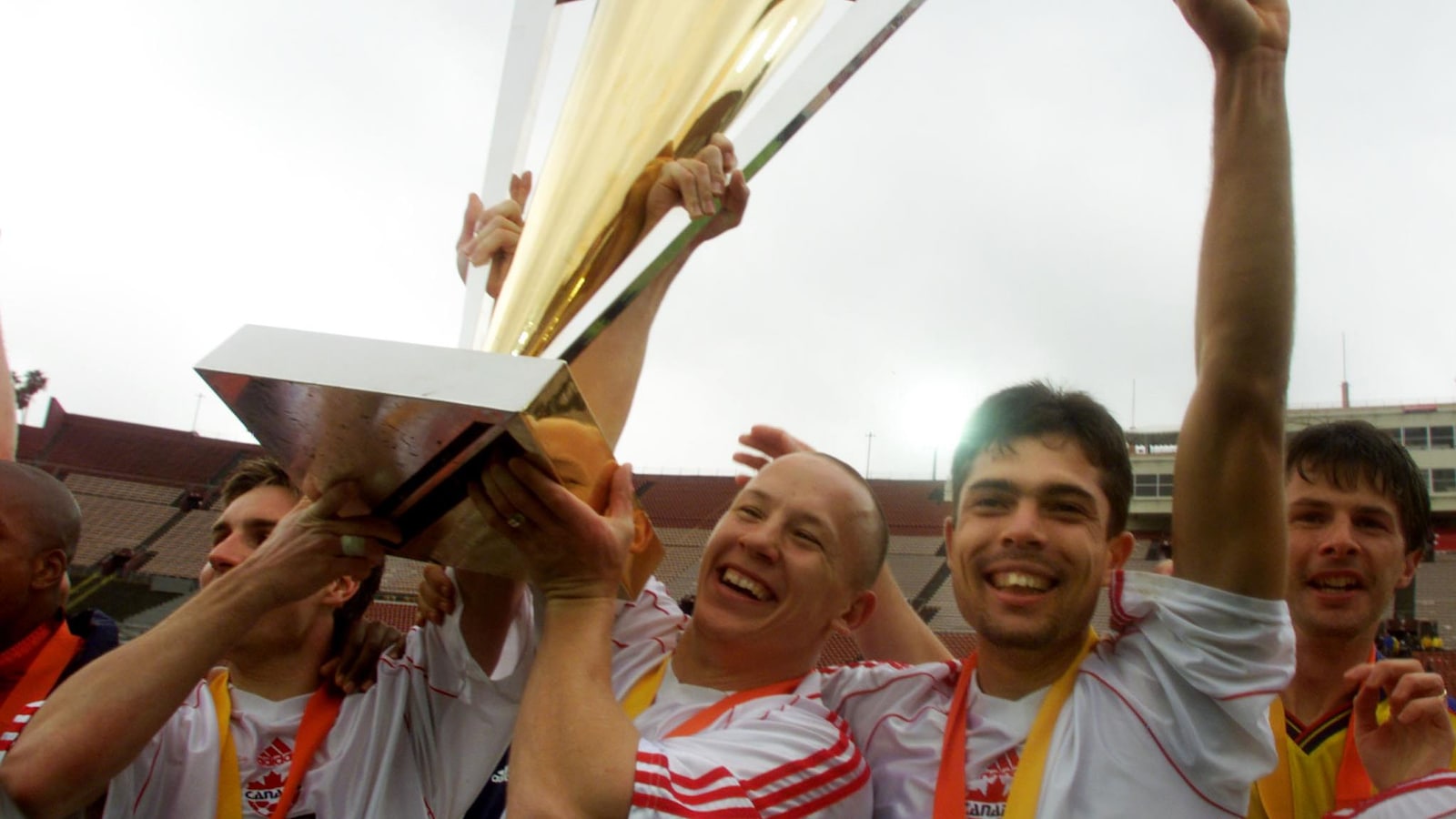 Jim Brennan, Garret Kusch et Paul Fenwick, du Canada, soulèvent le trophée après avoir vaincu la Colombie en finale du tournoi de la Gold Cup en 2000.
