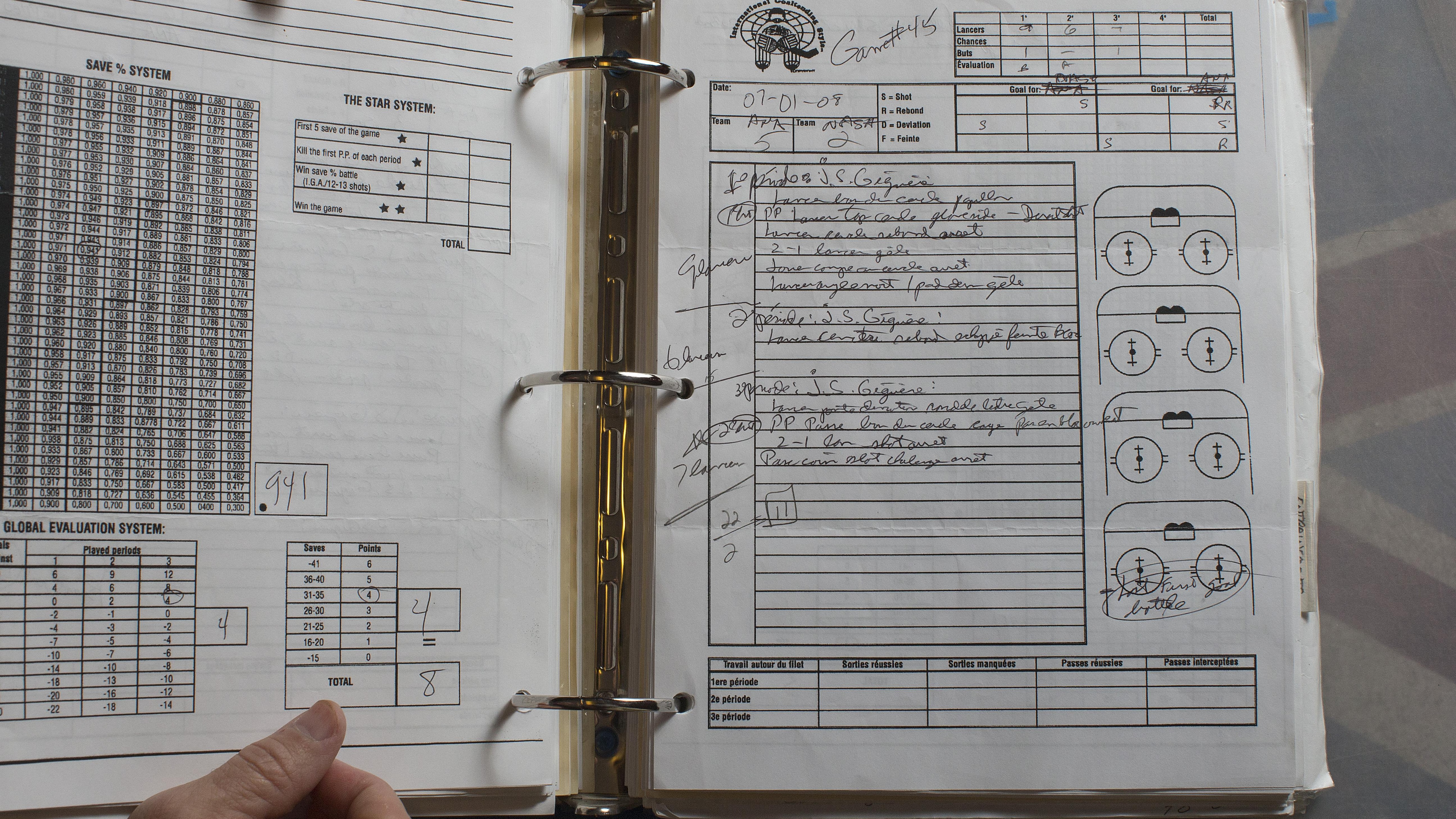 François Allaire montre un livre de notes prises après un match de Jean-Sébastien Giguère