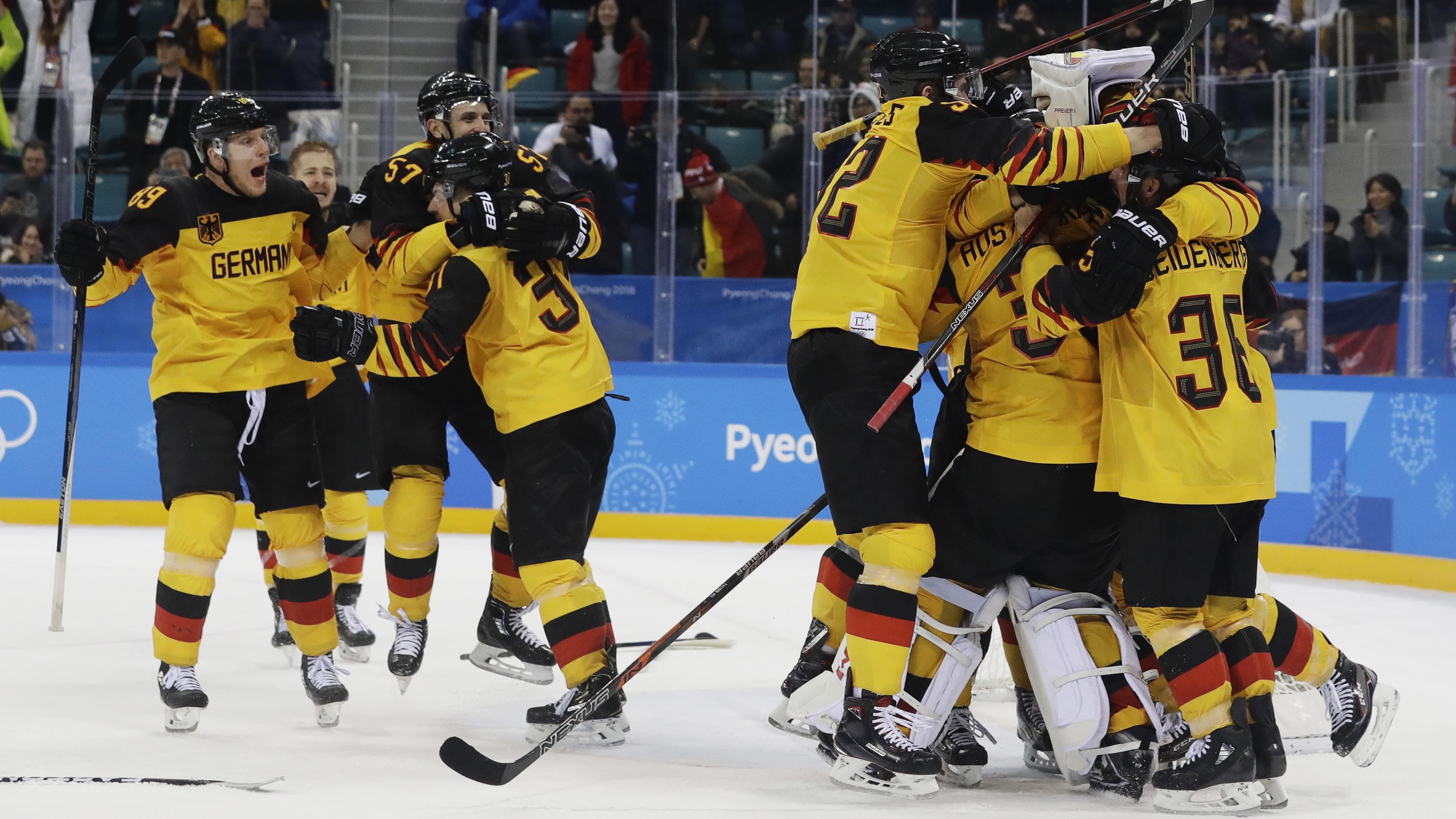 Les joueurs de l'équipe allemande se sautent dans les bras après avoir vaincu le Canada.