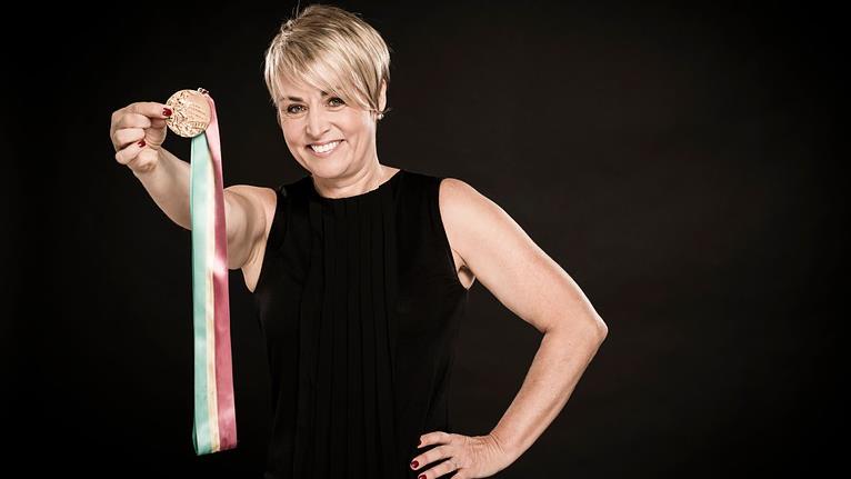 Sylvie Bernier montre fièrement sa médaille d'or.