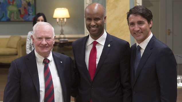 Le ministre de l'Immigration Ahmed Hussen pose aux côtés du gouverneur général, David Johnston, et du premier ministre du Canada Justin Trudeau.