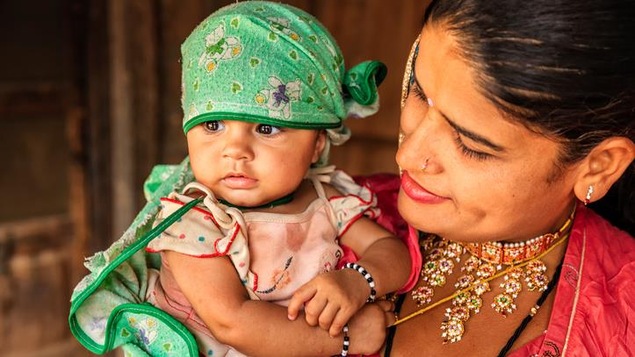 Un bébé  dans les bras de sa mère, dans un village du Rajasthan, en Inde