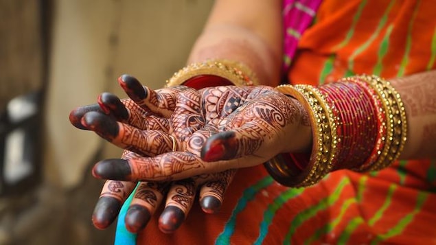 Selon la coutume, les mains de la mariée sont décorées avec du henné.