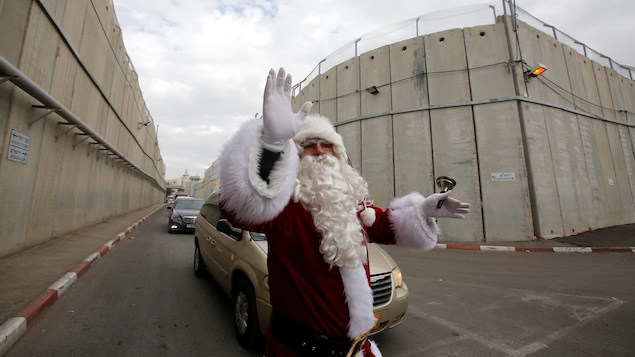 Un Palestinien déguisé en père Noël circule près d'un point de contrôle israélien. Un Palestinien déguisé en père Noël circule près d'un point de contrôle israélien.