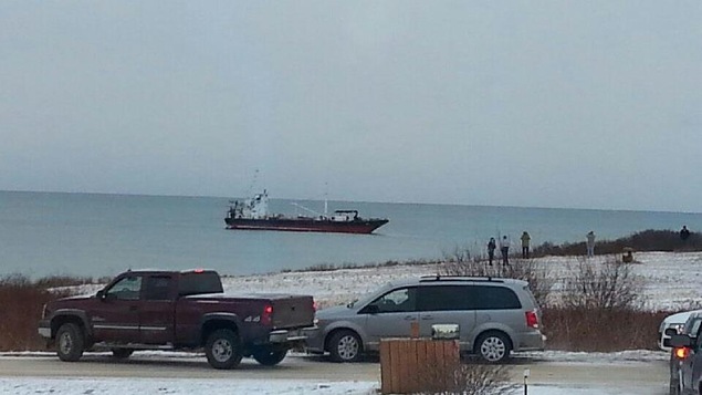 Des gens sur la côte regardent passer le navire Arca 1