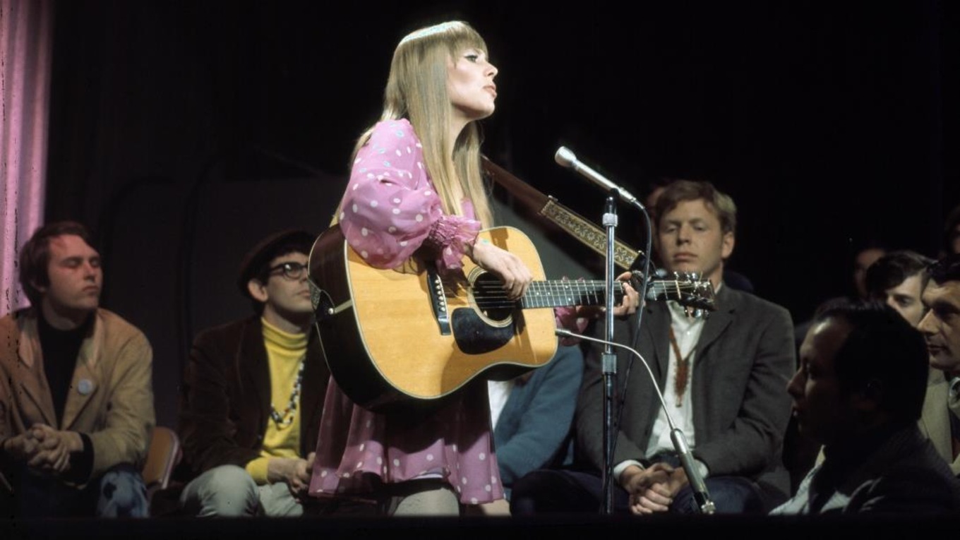 Joni Mitchell performing in front of an audience.