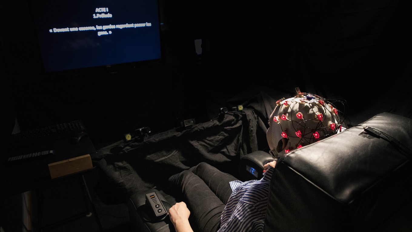 A volunteer watches an opera while wearing brain-monitoring equipment.