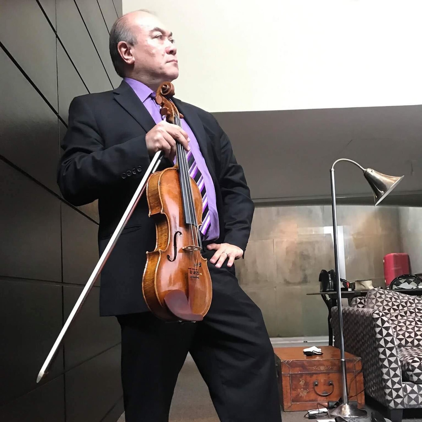 Pianist Jamie Parker impatiently holds somebody's viola.