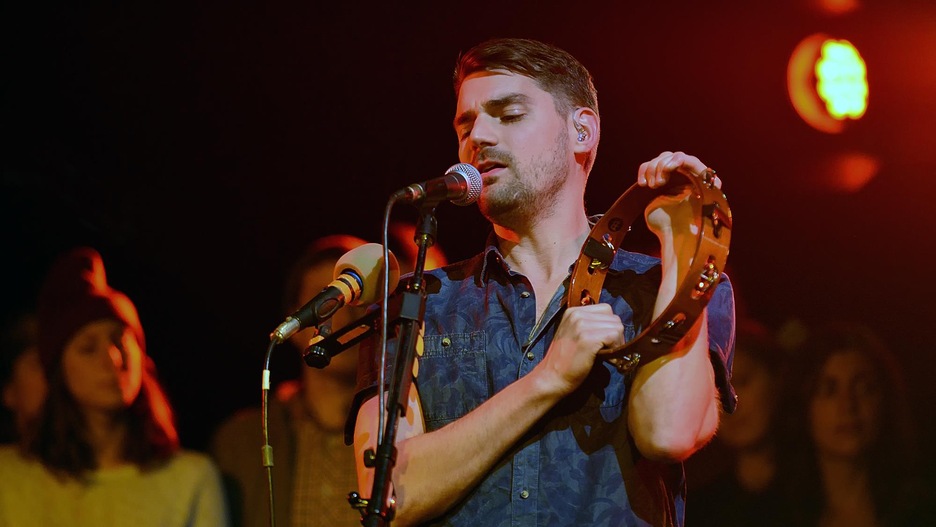 Hey Rosetta! frontman Tim Baker sings and plays tambourine in this photo.