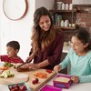 Une famille prépare des lunchs. 