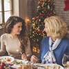 Une jeune femme et sa grand-mère discutant à table le soir de Noël.