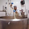 Un homme en train de brasser du fromage.