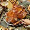 Une table festive avec une dinde rôtie entière.