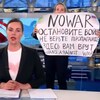 Une femme qui a surgi sur un plateau de télévision tient une pancarte disant : 
« Non à la guerre. Ne croyez pas la propagande. On vous ment, ici », derrière une lectrice de nouvelles. 