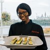 Une jeune femme tenant un plateau de sushi en main.
