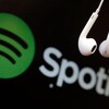 Des écouteurs devant le logo de Spotify. 