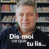 Michel Jean devant des rayons de livres et le logo de l'émission Dis-moi ce que tu lis.