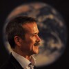 On voit Chris Hadfield devant la planète Terre.