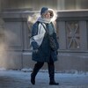 Une personne marche en ville dans le froid.