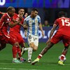 Lionel Messi attempting to dribble past the Canadian defense.