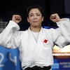 La judoka Christa Deguchi lève les poings en l'air.