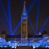 Des images bleutées et des lumières fusent sur la façade de l'édifice central du Parlement à Ottawa.