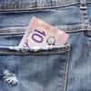 Un billet de 10 dollars canadiens dans la poche arrière d'un jean.