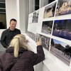 Une dame regarde les dessins du projet de revitalisation du centre-ville. Aaron Hansen la regarde et tente de répondre à ces questions.