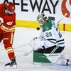 Le gardien des Stars de Dallas, Jake Oettinger (à droite) arrête une rondelle lancée par l'attaquant Dillon Dube durant la deuxième période d'une partie tenue à Calgary, le samedi 18 mars 2023.