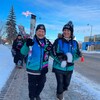Deux femmes portent une torche olympique dans les rues de Fort McMurray, en Alberta, le dimanche 29 janvier 2023.