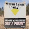 Un avis de danger élevé de feu de forêt est apposé à l'entrée d'un chemin d'accès à une exploitation de sables bitumineux au sud-est de Fort McMurray, en Alberta, le mercredi 24 avril 2024.