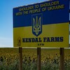 Un champ de tournesols au pied d'une grande affiche marquant la solidarité de la ferme Kendal Farms avec les réfugiés ukrainiens à Grande Prairie, en Alberta, à l'été 2022.
