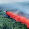 Un avion épand du retardant afin de limiter la propagation du feu de forêt de Carrot Lake, qui fait rage dans les environs du lac Chipewyan, en Alberta, au début de juin 2023.