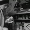 Femme chaudement habillée remplissant les tablettes de conserves de son abri antinucléaire