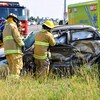 Deux pompiers manient la pince de désincarcération sur la voiture accidentée