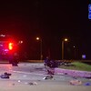Une camionnette est à l'arrêt. Un scooter est renversé sur la route le soir. Des débris sont sur la chaussée. 