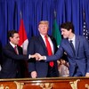 Le président américain Donald Trump, entouré d'Enrique Pena Nieto et de Justin Trudeau qui se serrent la main.