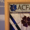 Le logo de l'Association canadienne-française de l'Alberta et le drapeau franco-albertain représentés sous forme de vitrail.