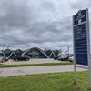 L'aéroport de Trois-Rivières. Des voitures sont stationnées devant le bâtiment.