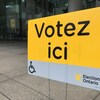 Une affiche jaune qui dit : Votez ici.