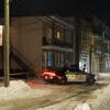 Un véhicule de la Sûreté du Québec dans une rue enneigée, devant un scène de crime.