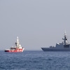 Un navire de sauvetage Open Arms, faisant partie d'une flottille de trois navires transportant de l'aide alimentaire pour la bande de Gaza, navigue à côté de la frégate française Courbet près du port de Larnaca, à Chypre, le 30 mars 2024. 