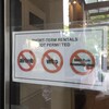Une affiche collée dans la vitre d'un immeuble indique que les locations à court terme y sont interdites.