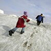 Deux enfants escaladent une montagne de neige à Browerville, en Alaska, le 7 juin 2006. 